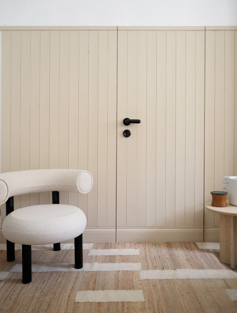 Cremefärgad dörr med svart handtag