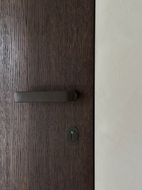 Närbild på mörk trädörr från njord design med svart beslag